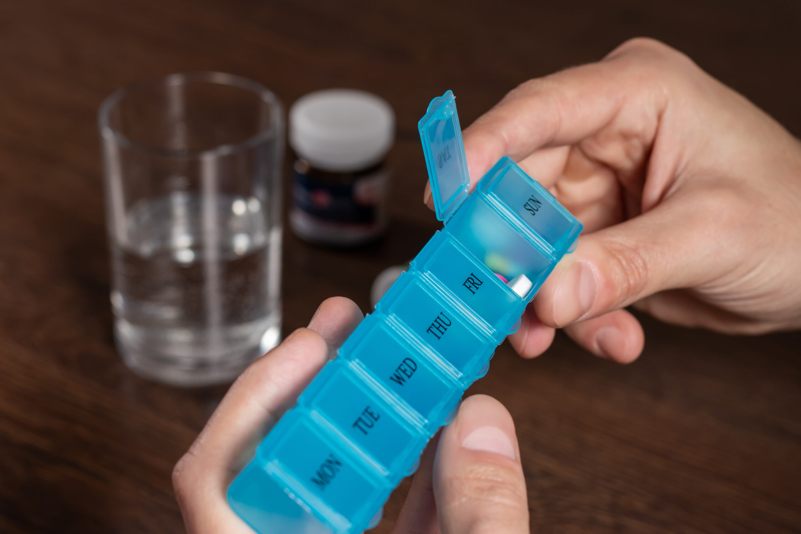 Male hand puts daily portion of vitamins, drug medicines, tablets